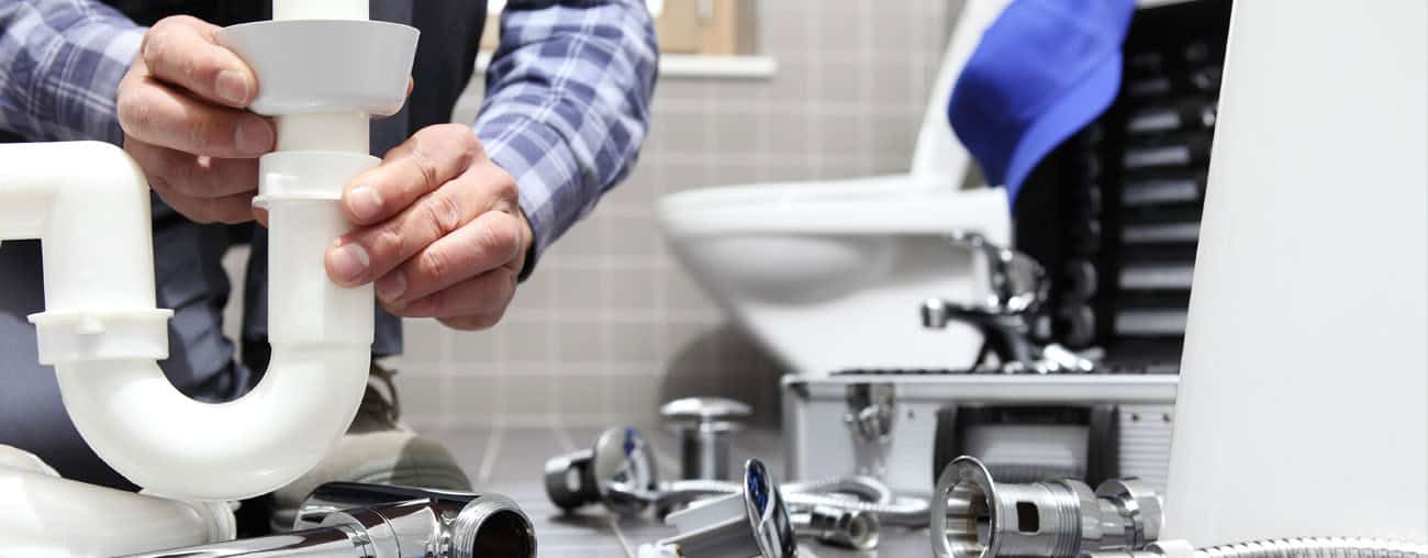 Plumber repairing piping in a residential bathroom
