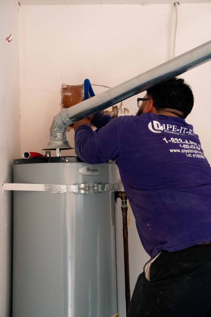 Pipe It Right water heater repair on a tank water heater in a garage