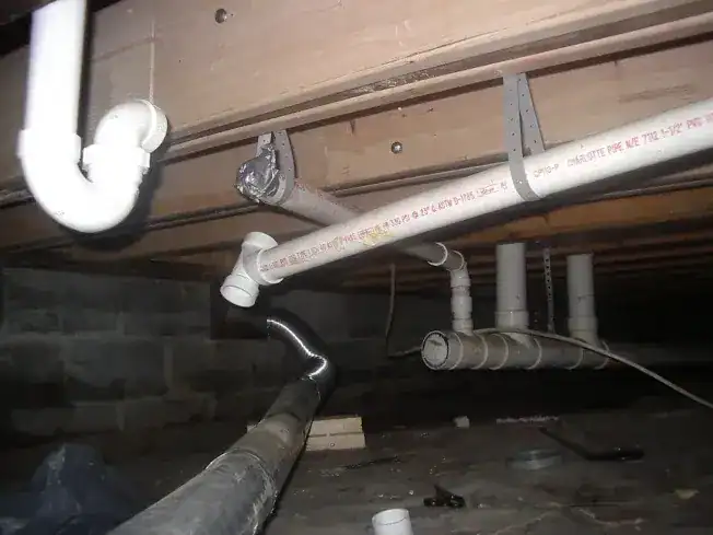 Drain rerouting project in progress under a house