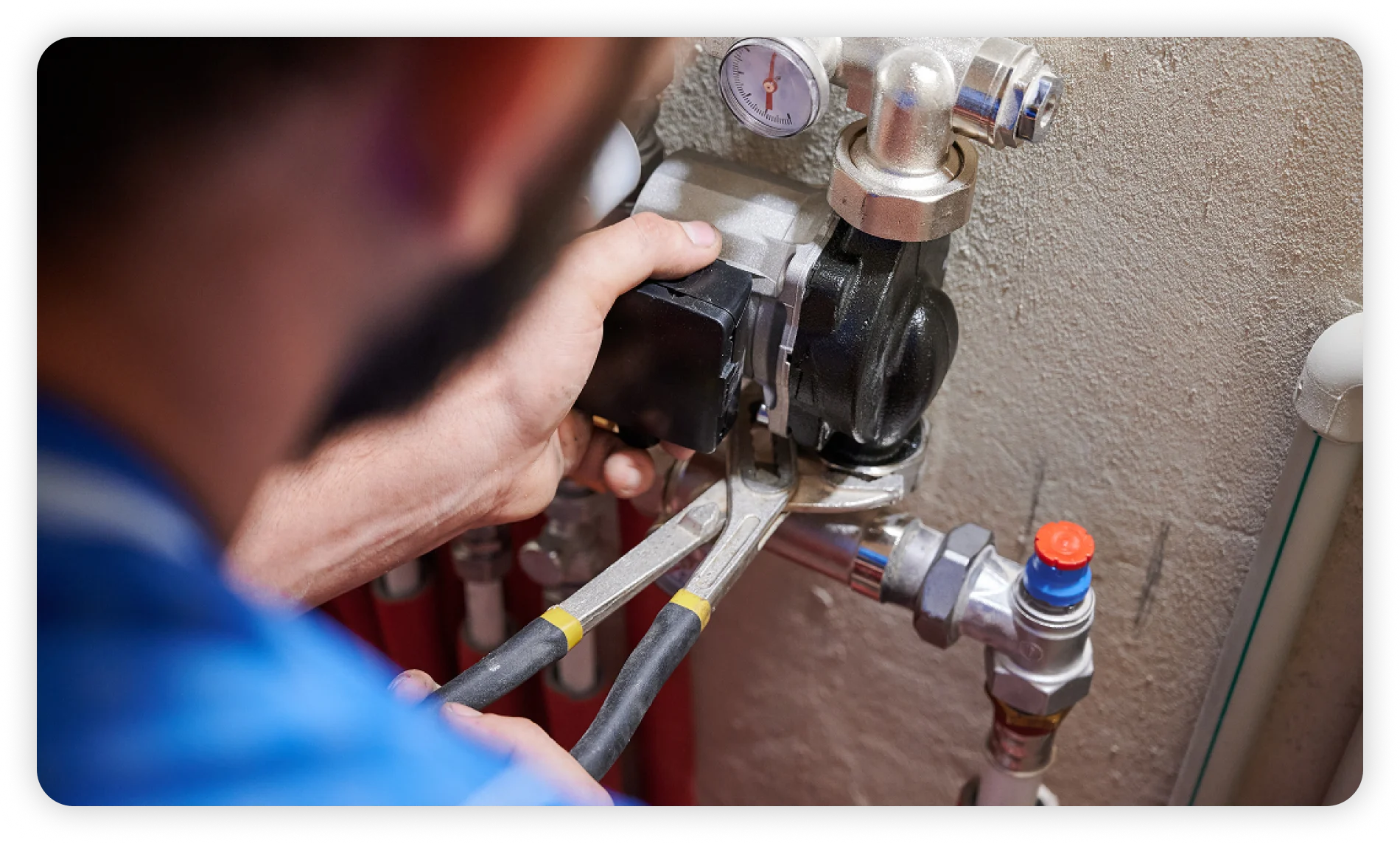 Plumber repairing a water heater with tools and pipe fittings