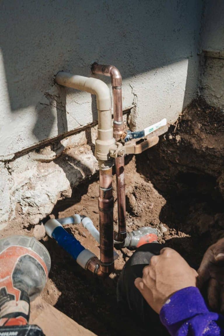 Plumbers installing new copper pipes to replace an older plumbing system