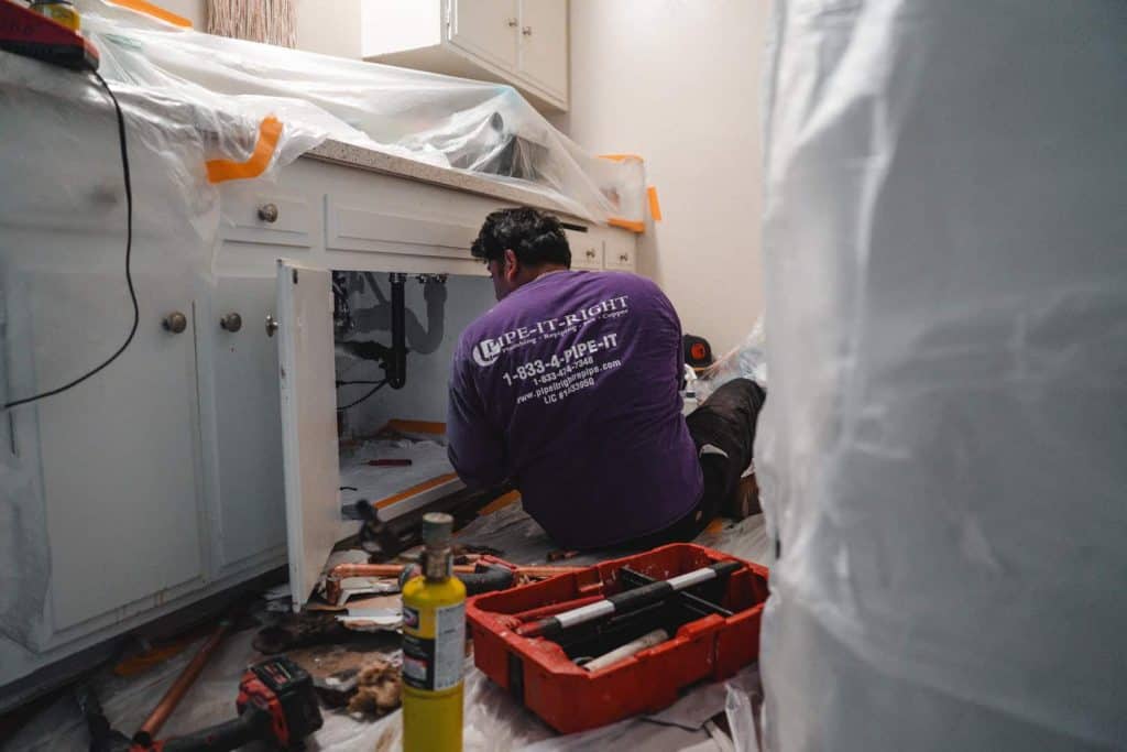Plumbing repairing the drains under a bathroom sink