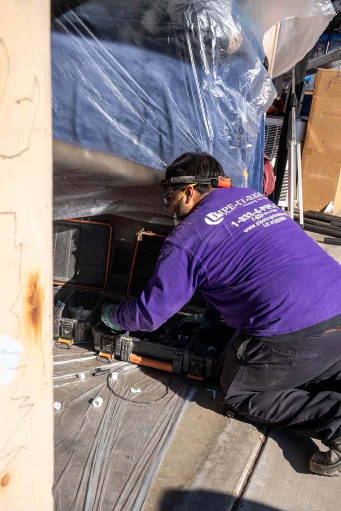 Plumbing technician sorting through the correct tools for a home repiping
