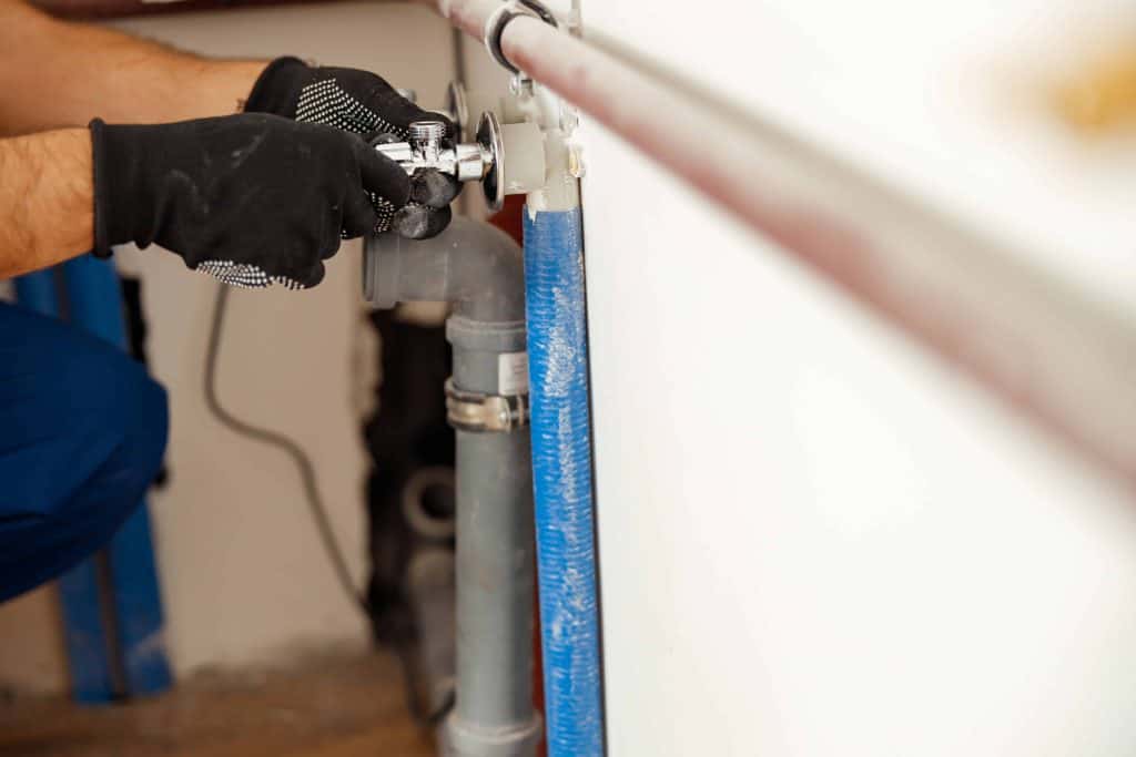 Closeup of hands of plumber checking pipes to ensure they are properly connected